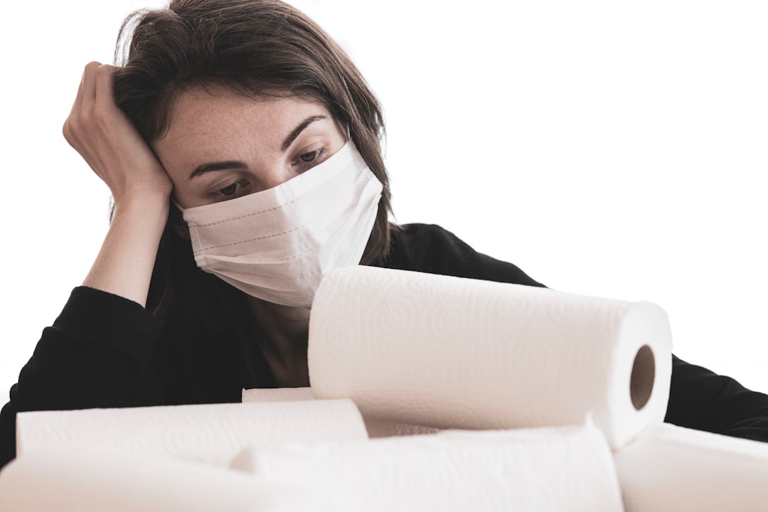 Mujer con mascarilla y baja médica consulta a Barcelona Laboral si puede reclamar su despido estando enferma
